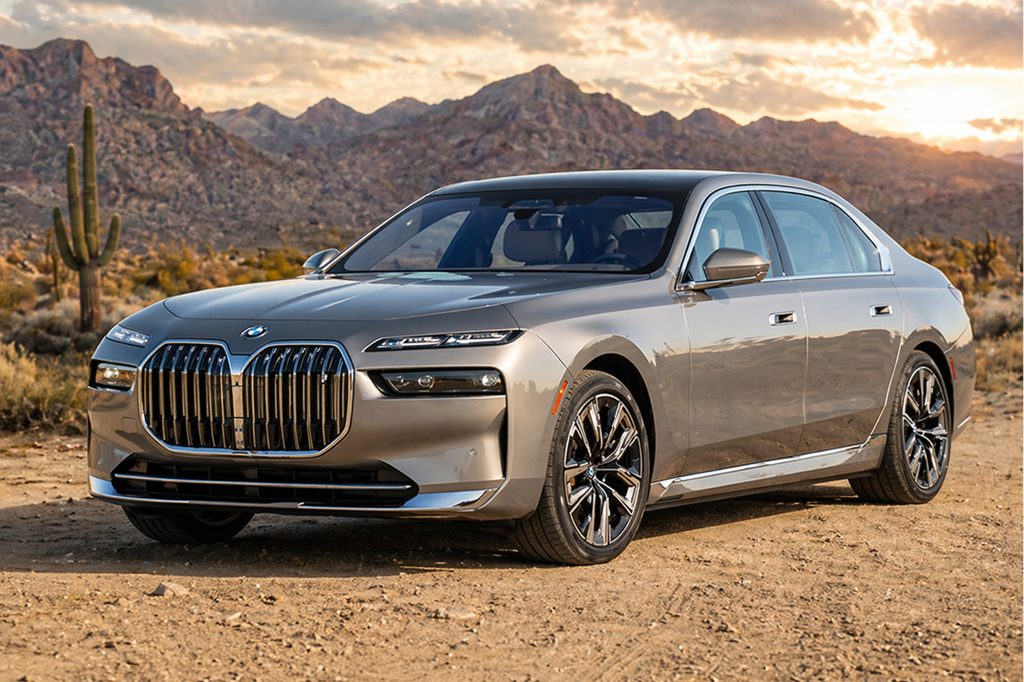 BMW 7 Series armoured sedan on desert terrain at sunset.